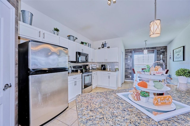 kitchen featuring light tile patterned flooring, hanging light fixtures, white cabinetry, stainless steel appliances, and lofted ceiling