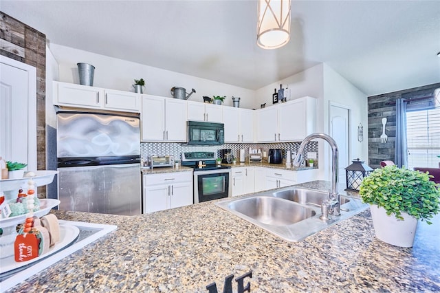 kitchen featuring stainless steel appliances, sink, decorative light fixtures, white cabinetry, and tasteful backsplash