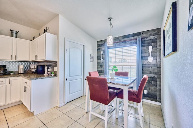 kitchen featuring light tile patterned flooring, white cabinetry, and decorative light fixtures