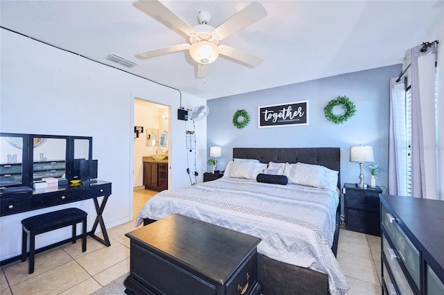 bedroom with ensuite bath, light tile patterned floors, and ceiling fan