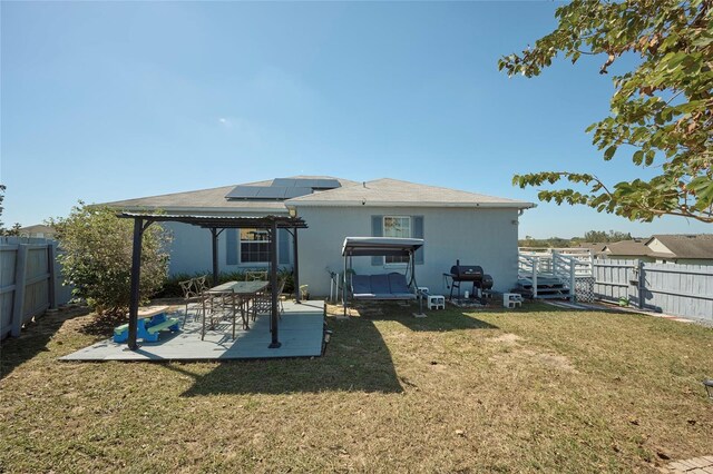 612 Chicago Way, Dundee, FL 33838 - back of property with a pergola, solar panels, and a patio