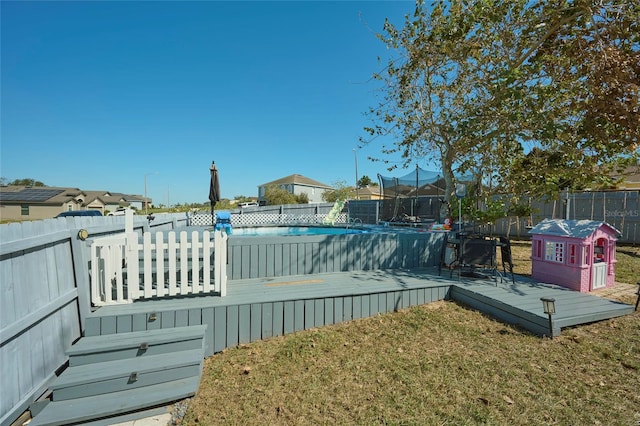 view of pool featuring a deck and a lawn