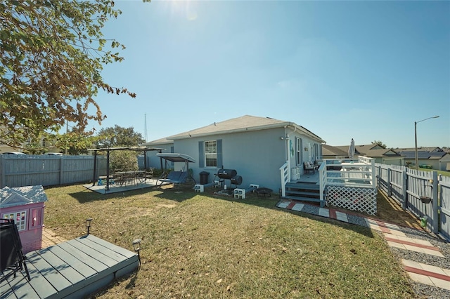 rear view of house featuring a patio area, a deck, and a lawn