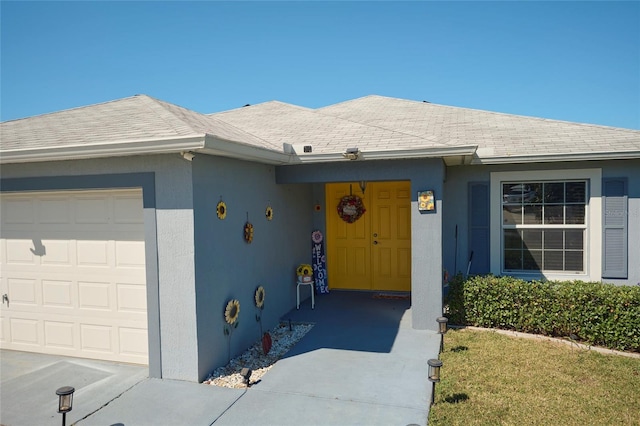 doorway to property featuring a garage and a lawn