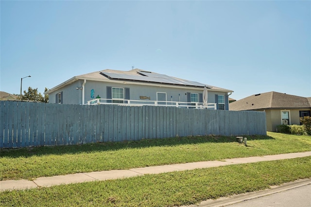 exterior space featuring solar panels and a yard