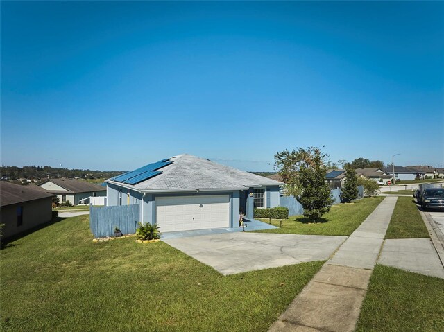 612 Chicago Way, Dundee, FL 33838 - single story home featuring solar panels, concrete driveway, a residential view, and a garage