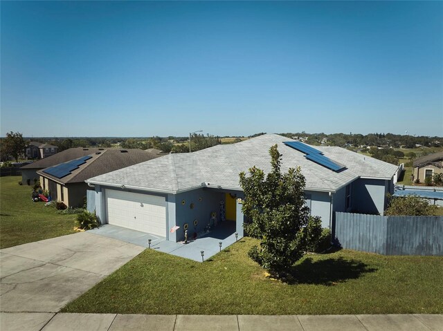 612 Chicago Way, Dundee, FL 33838 - ranch-style home with roof mounted solar panels, a garage, driveway, stucco siding, and a shingled roof