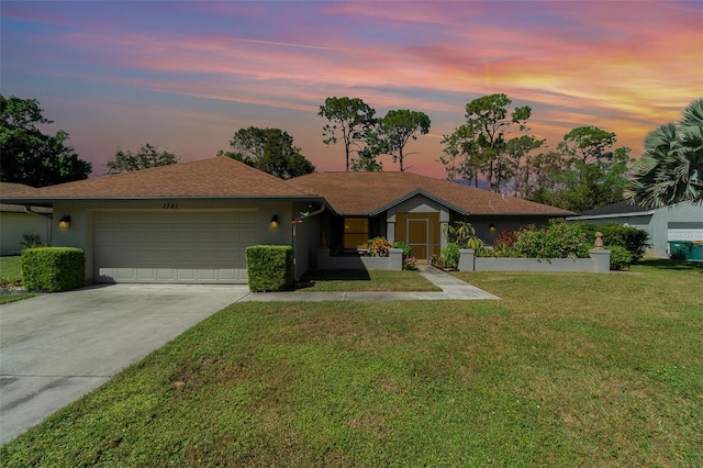 ranch-style house with a garage and a yard