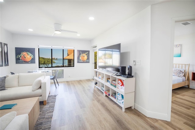 living room featuring light hardwood / wood-style flooring, a healthy amount of sunlight, and ceiling fan