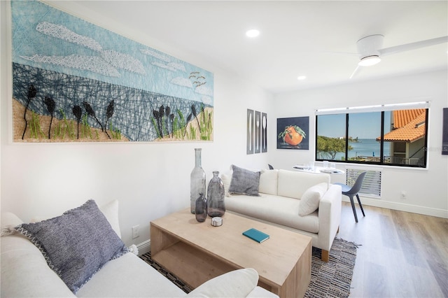 living room with light hardwood / wood-style floors and ceiling fan