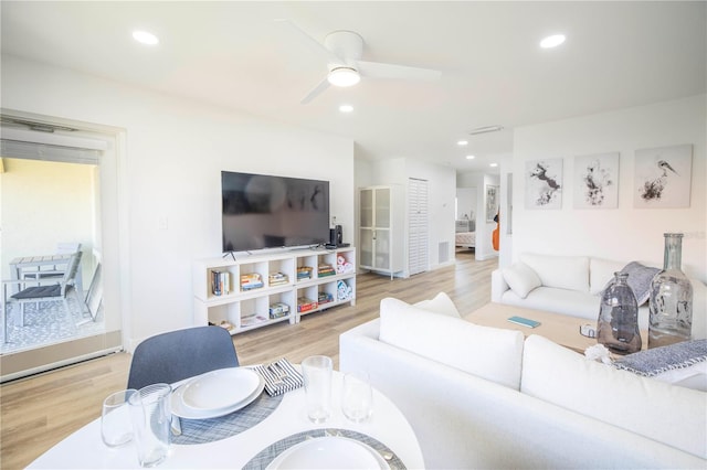 living room with light wood-type flooring and ceiling fan