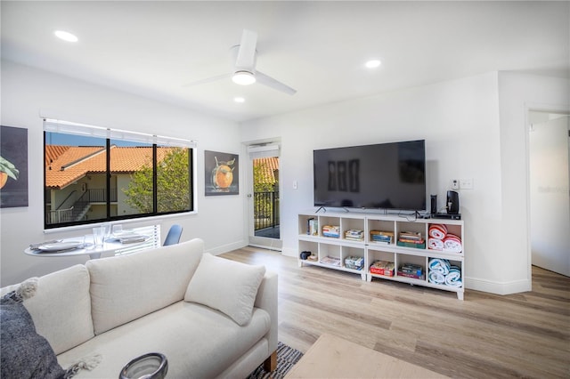 living room featuring ceiling fan and hardwood / wood-style flooring