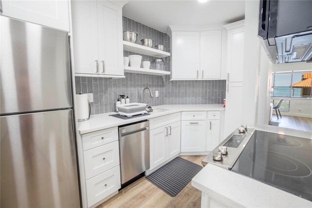 1515 Pinellas Bayway S Unit B28, Tierra Verde, FL 33715 - kitchen with stainless steel appliances, light wood-type flooring, light countertops, and a sink