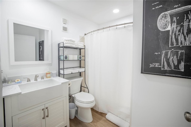 bathroom with vanity, toilet, a shower with shower curtain, and hardwood / wood-style floors