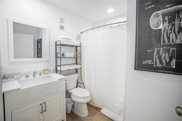 1515 Pinellas Bayway S Unit B28, Tierra Verde, FL 33715 - bathroom featuring toilet, vanity, wood finished floors, curtained shower, and recessed lighting