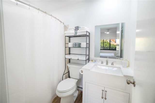 bathroom with vanity, toilet, hardwood / wood-style flooring, and baseboard heating