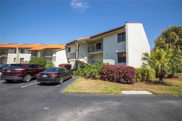 view of front of house with a balcony and a front lawn