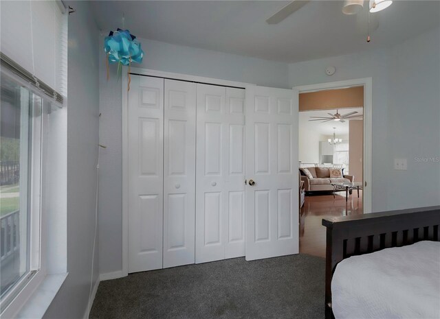 carpeted bedroom with ceiling fan and a closet