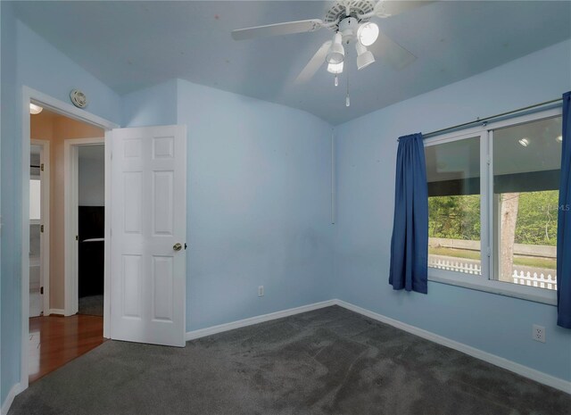 carpeted empty room with ceiling fan and vaulted ceiling