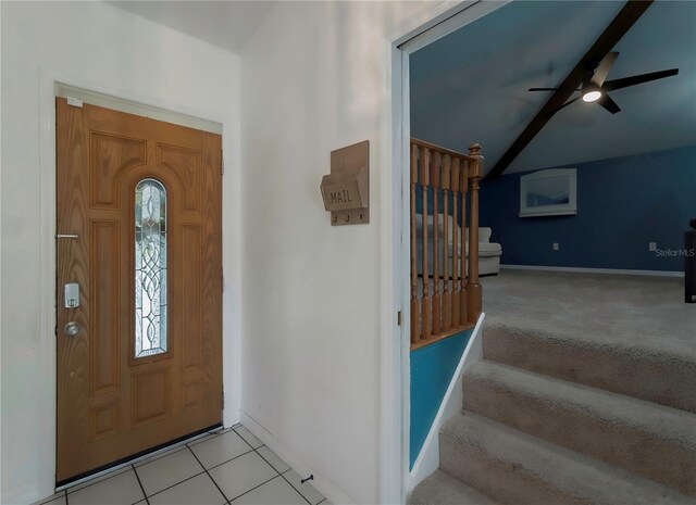 carpeted entryway featuring beamed ceiling and ceiling fan