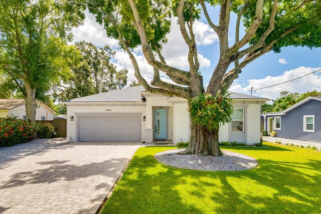 view of front of property with a garage and a front lawn