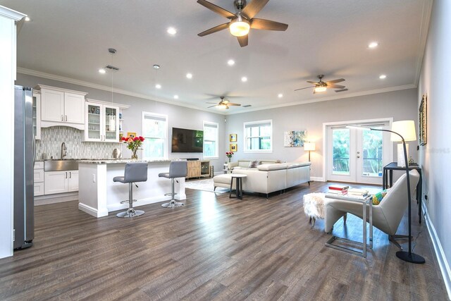 living room featuring ornamental molding, ceiling fan, sink, and dark hardwood / wood-style flooring