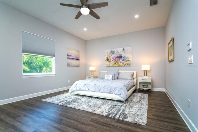 bedroom with dark hardwood / wood-style flooring and ceiling fan