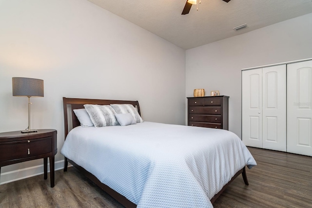 bedroom featuring dark hardwood / wood-style flooring, a textured ceiling, a closet, and ceiling fan