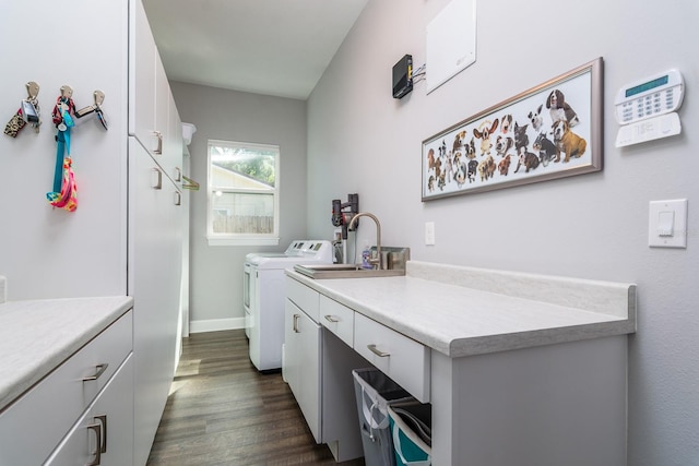 clothes washing area with dark wood-type flooring, cabinets, and separate washer and dryer