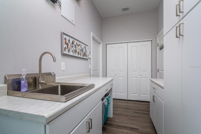 kitchen featuring dark wood-type flooring, a center island, white cabinetry, and sink