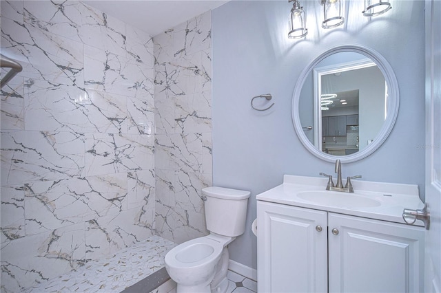 bathroom featuring vanity, a tile shower, and toilet