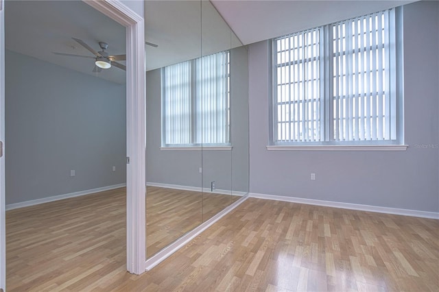 spare room featuring light hardwood / wood-style floors, a healthy amount of sunlight, and ceiling fan