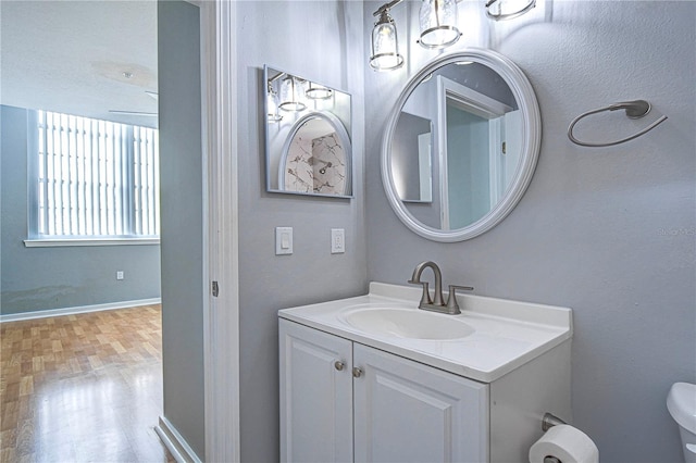 701 Mirror Lake Dr N Unit 309, Saint Petersburg, FL 33701 - bathroom featuring toilet, baseboards, vanity, and wood finished floors