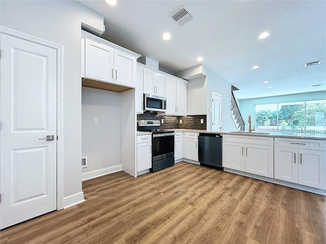 kitchen featuring appliances with stainless steel finishes, light hardwood / wood-style flooring, white cabinetry, and sink