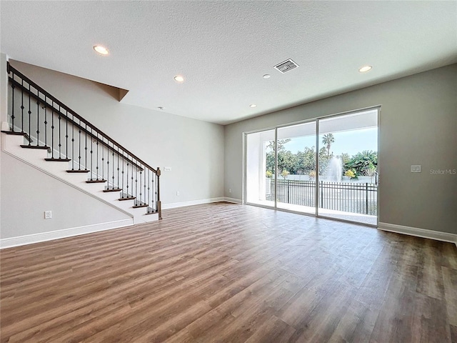 unfurnished living room featuring dark hardwood / wood-style floors and a textured ceiling