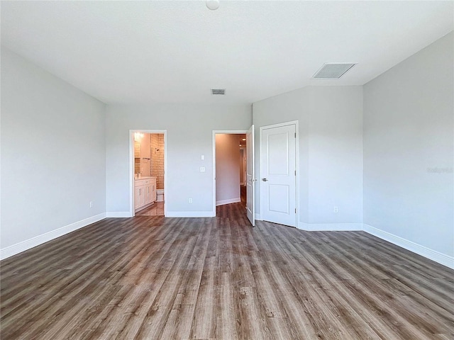 unfurnished bedroom featuring dark hardwood / wood-style floors, connected bathroom, and a closet