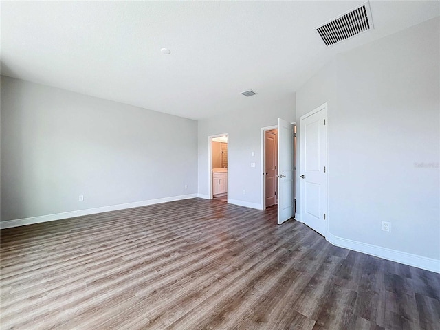 unfurnished bedroom with dark hardwood / wood-style floors and ensuite bathroom