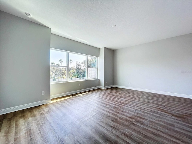 unfurnished room featuring a textured ceiling and dark wood-type flooring