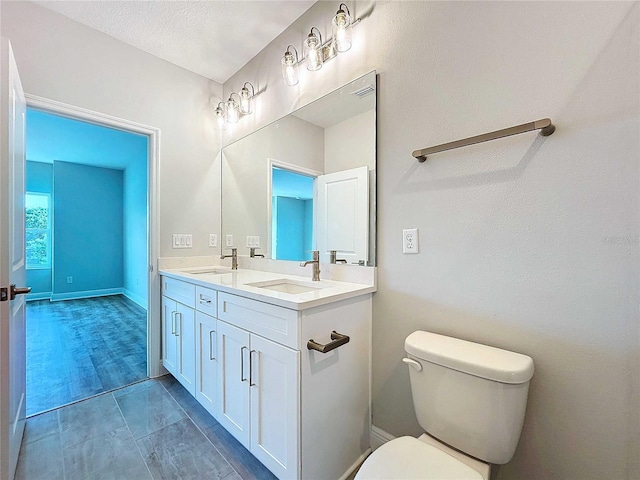 bathroom with tile patterned floors, vanity, toilet, and a textured ceiling