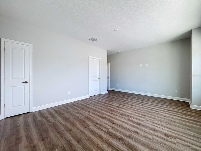 empty room with hardwood / wood-style floors and a textured ceiling