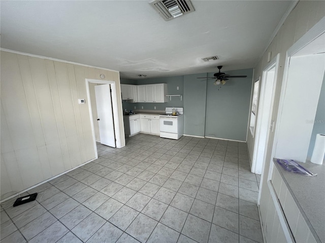 kitchen with electric stove, crown molding, ceiling fan, light tile patterned floors, and white cabinetry