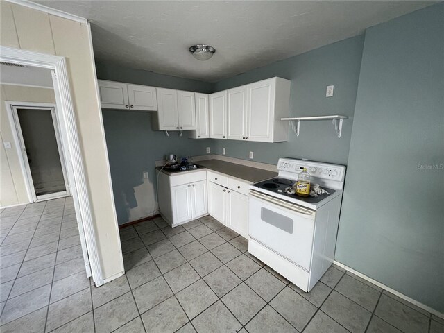 kitchen with white range with electric stovetop, white cabinetry, sink, and light tile patterned floors