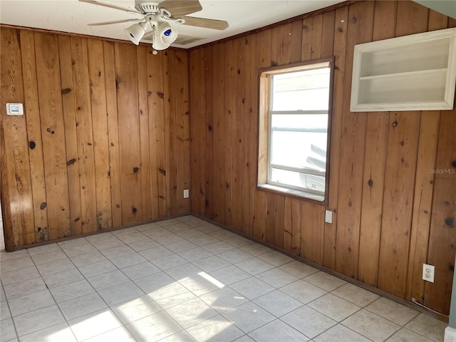 unfurnished room featuring light tile patterned flooring, ceiling fan, and wood walls