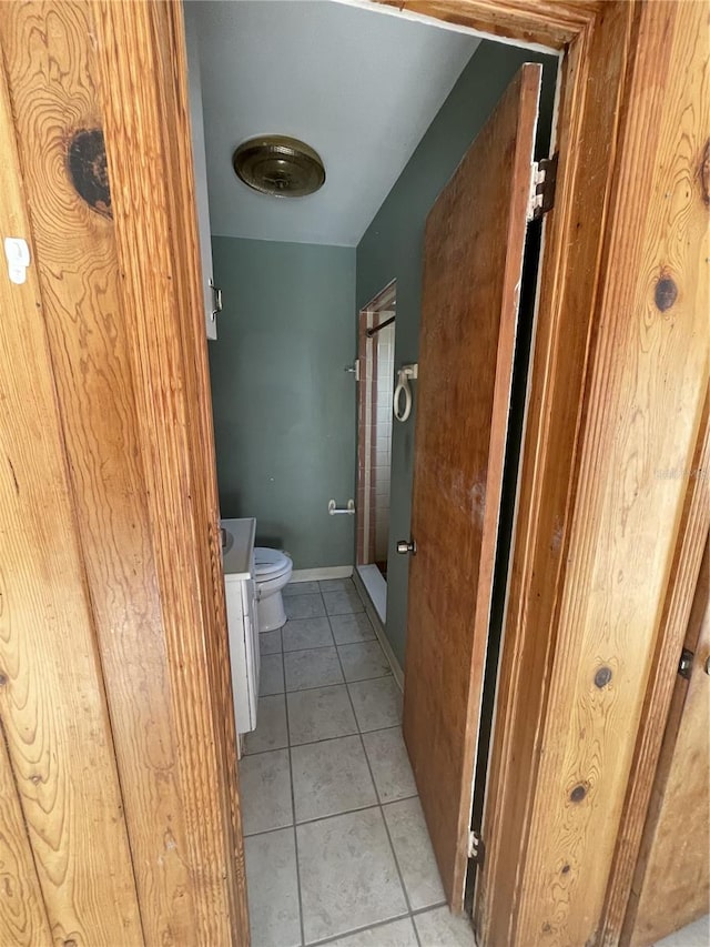 bathroom with tile patterned floors, vanity, walk in shower, and toilet