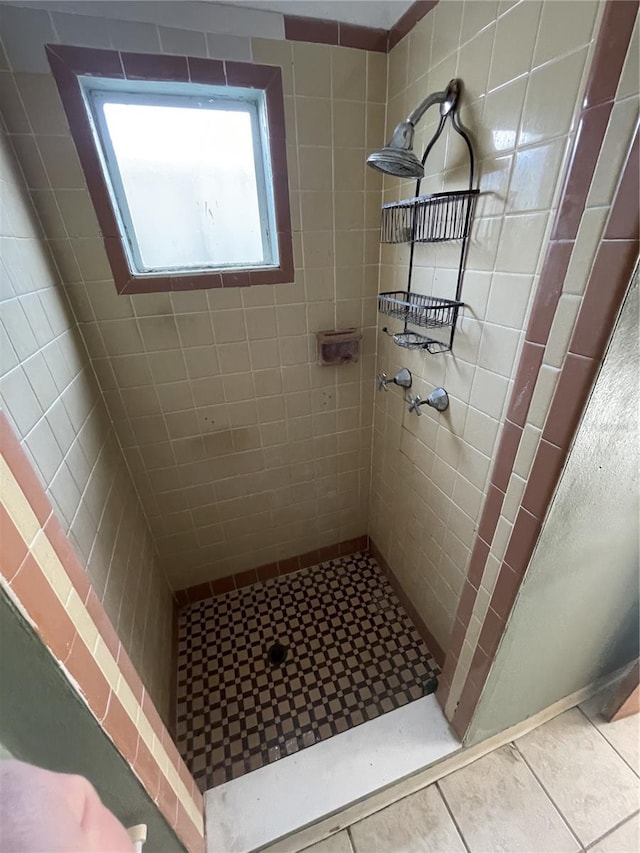 bathroom featuring tile patterned flooring and tiled shower