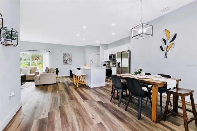 dining space featuring hardwood / wood-style floors and sink