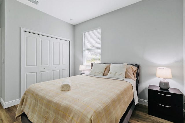 bedroom with dark hardwood / wood-style floors and a closet