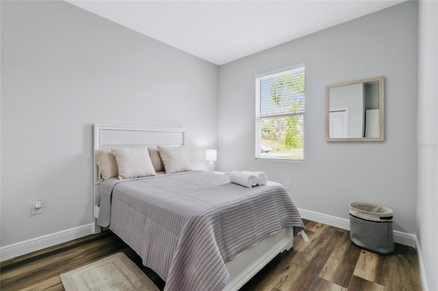 bedroom with dark hardwood / wood-style floors