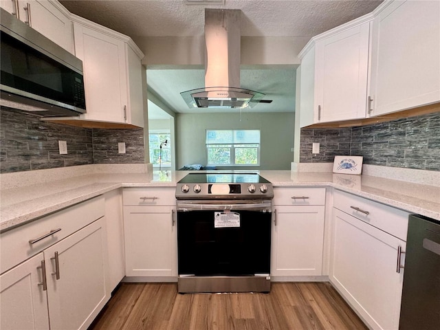 kitchen featuring white cabinetry, appliances with stainless steel finishes, light hardwood / wood-style flooring, and island range hood