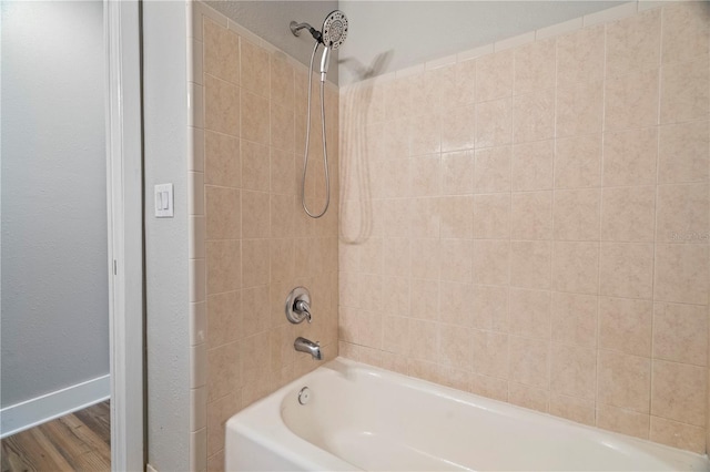 bathroom with tiled shower / bath combo and hardwood / wood-style floors